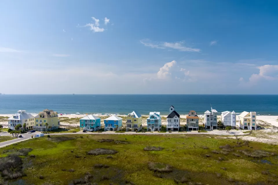 Row of colorful two-story beach homes on Gulf Coast beach in Alabama.